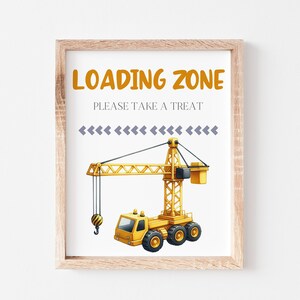 Może przedstawiać: Drukowany znak z żółtym żurawiem budowlanym i tekstem "Loading Zone Please Take A Treat" w kolorze pomarańczowym i szarym.