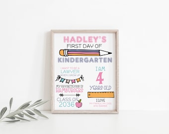 Op de afbeelding: Een ingelijste print met de tekst "Hadley's First Day of Kindergarten." De print bevat een potloodillustratie en details zoals "Ik wil advocaat worden", "Ik ben 4 jaar oud" en "Mijn favoriete eten is hamburgers."