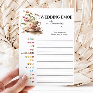 May include: A printable wedding emoji pictionary game with a floral illustration of a teacup. The game includes a list of emojis and blank lines for players to write down their guesses.