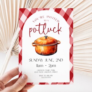 Op de afbeelding: Een rode en witte gingham-gepatroneerde uitnodiging voor een potluck. De uitnodiging bevat een aquarel-illustratie van een bruine pot met een deksel. De tekst op de uitnodiging luidt "You're invited to a potluck", "Sunday June, 2nd", "11am - 2pm", "Creston Family Park", "12345 West Creston Street", "RSVP to Hillary", en "5555555555".
