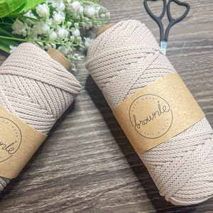 May include: Two spools of beige cotton rope with a brown paper label that says "hand made brownle knit & crochet".