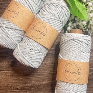 May include: Three spools of light gray cotton rope with brown paper labels that say "hand made brownle knit & knot".