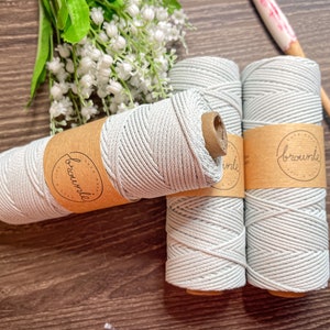 May include: Three spools of light gray cotton cord wrapped in brown paper with a "brownie" label.