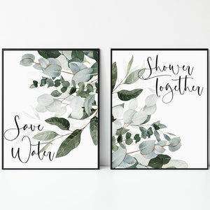 Puede incluir: Dos impresiones enmarcadas con un diseño de eucalipto en acuarela. La impresión de la izquierda dice "Save Water" y la impresión de la derecha dice "Shower Together".