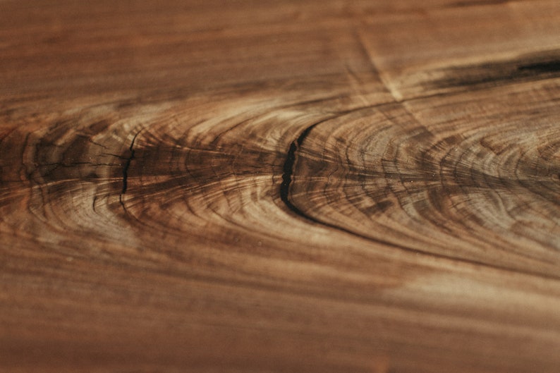 May include: Close-up of a wood grain pattern with a dark brown colour and a light brown colour. The wood grain has a natural, organic look.