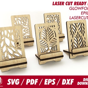 May include: Four laser cut wooden phone stands with intricate leaf designs. The stands are made of light brown wood and have a black base. The designs are cut out of the wood, creating a delicate and elegant look.  LASER CUT READY FILE GLOWFORGE EPILOG LASERCUTTER SVG/PDF/EPS/DXF DIGITAL DOWNLOAD