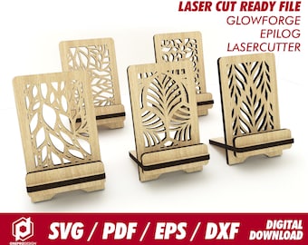 May include: Four laser cut wooden phone stands with intricate leaf designs. The stands are made of light brown wood and have a black base. The designs are cut out of the wood, creating a delicate and elegant look.  LASER CUT READY FILE GLOWFORGE EPILOG LASERCUTTER SVG/PDF/EPS/DXF DIGITAL DOWNLOAD