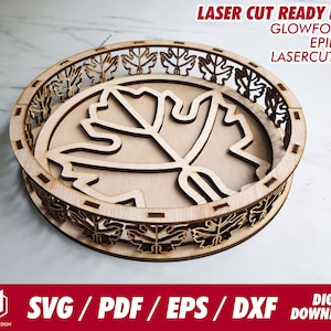 May include: A laser cut wooden tray with a leaf design. The tray is made of light brown wood and has a decorative border of leaves. The tray is perfect for serving snacks or drinks.