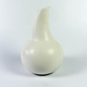 May include: A white ceramic vase shaped like a pear with a narrow neck.