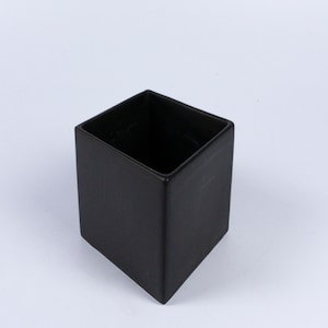 May include: A black square ceramic planter. The planter is empty and has a smooth, matte finish.