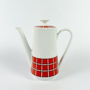 Pode incluir: Bule de café de cerâmica branca com um design xadrez vermelho e preto ao redor da base.
