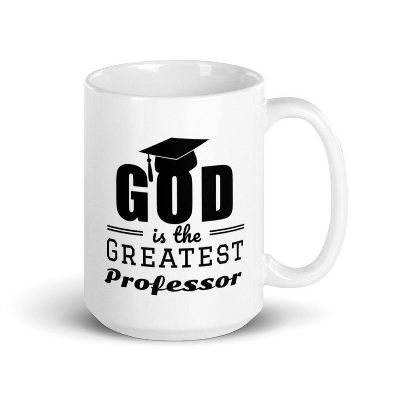 Pu&ograve; includere: Tazza da caff&egrave; in ceramica bianca con una grafica nera che recita "GOD is the GREATEST Professor" con un cappello di laurea sopra la parola "GOD".