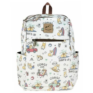 May include: White canvas backpack featuring a colourful pattern of corgis surfing, driving cars, and relaxing on the beach. The backpack has a brown leather handle and zipper pulls. The text "CORGI" and "SURF'S UP" is repeated throughout the pattern.