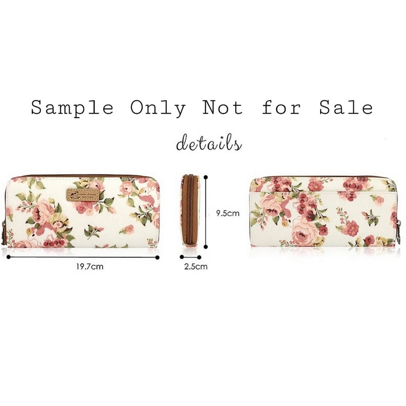 May include: A white canvas zippered wallet with a floral print in shades of pink and green. The wallet measures 7.75 inches long, 2.5 inches wide, and 3.75 inches tall.