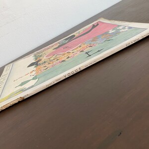 May include: A vintage Vogue magazine cover from November 1918, featuring a woman in a pink dress and a black hat. The cover is illustrated with flowers and the text "Vogue, 461 West 42nd Street, New York City, $5.00 a year, 24 numbers".