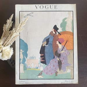 May include: A vintage Vogue magazine cover from May 15, 1918, titled Summer Homes Number. The illustration features two figures in period clothing, one holding an orange parasol, with a biplane in the sky and classical statues in a garden.
