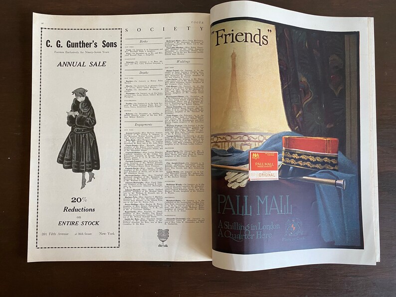 Puede incluir: Una p&aacute;gina de revista antigua que presenta un anuncio de C. G. Gunther's Sons con una figura vestida de piel a la izquierda y un anuncio de cigarrillos Pall Mall a la derecha, mostrando una caja roja y dorada, guantes blancos y un bast&oacute;n sobre tela azul.