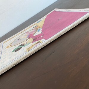 Puede incluir: Una edici&oacute;n vintage de la revista Vogue del 15 de febrero de 1918 con una colorida ilustraci&oacute;n de una persona con un vestido largo magenta mirando en un espejo. La portada incluye el texto Vogue, New York City y Spring Millinery Number.