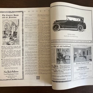 May include: A vintage magazine spread featuring black and white advertisements and text. The left page displays an article titled The Country House and its Furniture. The right page shows a Locomobile Touring Model car and advertisements for Ideal heating and Harrison's Sanitary Flat Wall Finish.