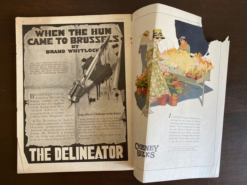 May include: A magazine page with a black and white illustration of a bayonet and a text article titled "When the Hun Came to Brussels" by Brand Whitlock. The article discusses the German invasion of Belgium during World War I. The opposite page features a color illustration of a woman in a floral dress buying flowers from a street vendor. The text on this page reads "In Cheney Silks, Paris's foremost designers will lend the new season of Cheney Silkship the same brand of other fabrics. But it is the fusion of all the new Cheney Silks and our charming designs that bring the final discovery of design, and the possibilities for those who want to look, but do a scarcely ground."