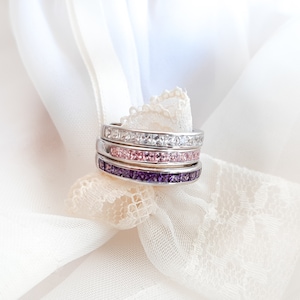 1 carat princess-cut channel set sterling silver ring with brilliant simulated amethyst CZ stones, beautifully packaged in a ribbon-tied gift box. Elegant and versatile band perfect for stacking, wearing alone, or pairing with an engagement ring