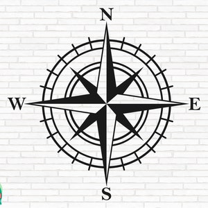 May include: Black and white compass with the letters N, S, E, and W. The compass is on a white brick background.