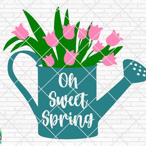以下が含まれることがあります： ピンクの花束が入ったターコイズブルーのじょうろ。じょうろには持ち手と注ぎ口があります。じょうろの前には「Oh Sweet Spring」という文字が書かれています。