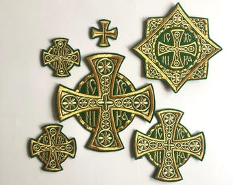 May include: A set of six embroidered patches featuring gold crosses on a green background. The crosses are decorated with intricate details and some have Cyrillic lettering.