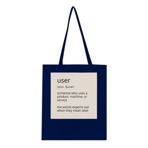 May include: Dark blue tote bag with black handles. The bag has a white rectangle with the word "user" and its pronunciation, along with a definition. The definition reads: "someone who uses a product, machine, or service".