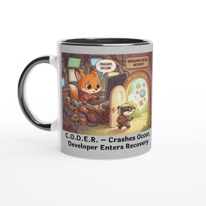 Könnte beinhalten: Weißer Keramikbecher mit schwarzem Innenraum und Henkel. Der Becher zeigt eine Cartoon-Illustration eines Fuchses am Computer und eines Dachses, der eine Tür mit der Aufschrift "Recovery Mode" betritt. Text auf dem Becher lautet "C.O.D.E.R. - Abstürze treten auf, Entwickler betritt die Wiederherstellung".