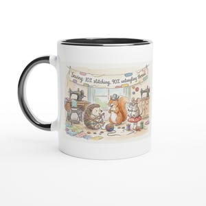 Könnte beinhalten: Weißer Keramikbecher mit schwarzem Henkel und Rand. Der Becher zeigt eine skurrile Illustration eines Igels, Eichhörnchens und einer Maus in einem Nähzimmer. Der Text auf dem Becher lautet: "Nähen: 10% Nähen, 90% Entwirren des Fadens."