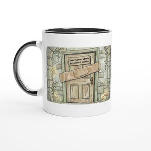 Peut inclure: Mug en céramique blanche avec une anse et un bord noirs. L'illustration fantaisiste représente une porte en bois avec un pansement, sur un mur en pierre. Le texte sur la porte indique "username: admin password: admin."