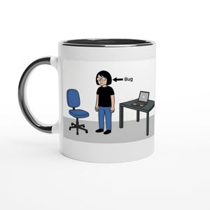 Könnte beinhalten: Weißer Keramikbecher mit schwarzem Innenraum und Henkel. Der Becher zeigt eine Cartoon-Illustration einer Person, eines Stuhls, eines Schreibtischs mit Laptop und das Wort "Bug" mit einem Pfeil auf die Person.