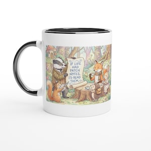 May include: White ceramic mug with a black rim and handle. The mug features a whimsical illustration of woodland animals, including a badger, fox, and squirrel, gathered around a scroll with the text "IF LIFE HAD PATCH NOTES, I'D READ THEM."