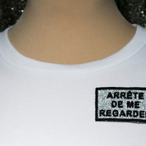 STOP LOOKING AT ME brooch silver fabric sequins rainbow reflections embroidered message in French black thread outline made in France