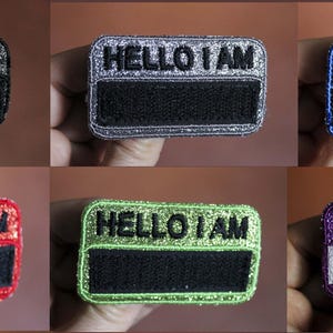 Choice of HELLO I AM rectangle badge base with rounded edges, colored sequined fabric, embroidered with black or white thread, tone-on-tone thread outline + Velcro