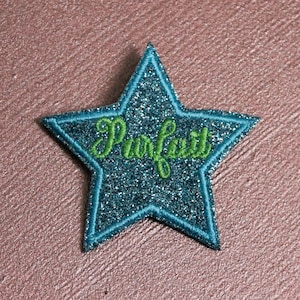 May include: A teal blue glitter star with the word "Perfect" embroidered in green.