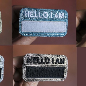 Könnte beinhalten: Vier glitzernde Namensschilder mit dem Text "Hello I am" und einem leeren Platz für einen Namen. Die Namensschilder sind in Gold, Silber, Blau und Rosa.
