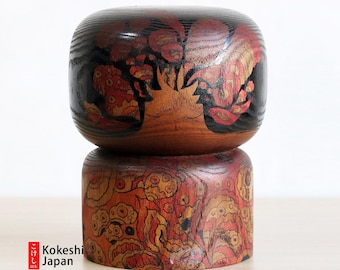 May include: A traditional Japanese Kokeshi doll with a black and red painted design. The doll is made of wood and has a round body with a small head. The doll is standing on a wooden base.