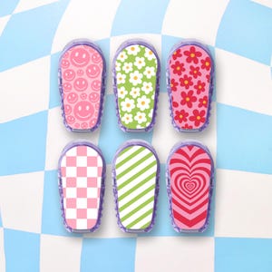 May include: Six colorful patterned stickers for a medical device. The stickers feature designs like smiley faces, flowers, checkered patterns, stripes, and hearts.