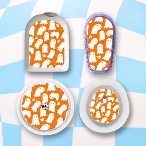 May include: Four medical device accessories with a Halloween theme. Each item features a repeating pattern of white cartoon ghosts on an orange background. The items are in various shapes and sizes, including a rectangular case and circular patches.