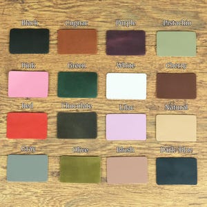 May include: A grid of sixteen rectangular leather swatches in various colors, each labeled with text including Black, Cognac, Purple, Pistachio, Pink, Green, White, Cherry, Red, Chocolate, Lilac, Natural, Gray, Olive, Blush, and Dark-Blue.