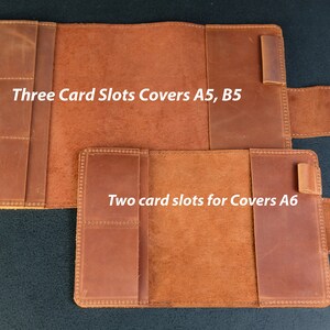 May include: Two leather notebook covers with card slots. The larger cover has three card slots and is labeled "Three Card Slots Covers A5, B5". The smaller cover has two card slots and is labeled "Two card slots for Covers A6".