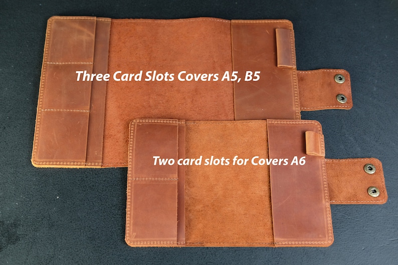 May include: Two leather notebook covers with card slots. The larger cover has three card slots and is labeled "Three Card Slots Covers A5, B5". The smaller cover has two card slots and is labeled "Two card slots for Covers A6".
