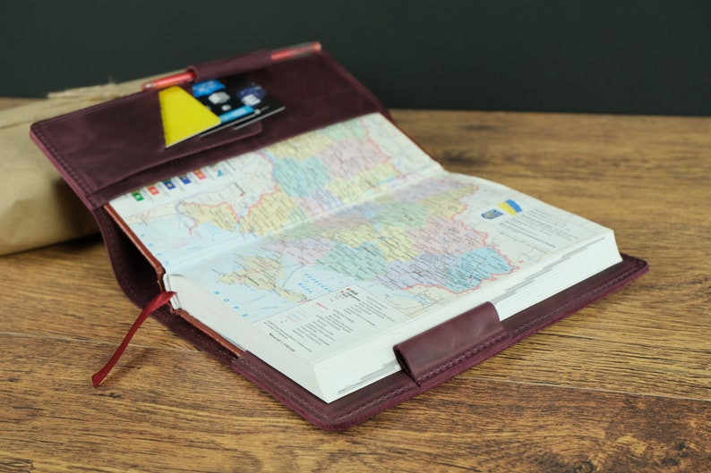 May include: A burgundy leather journal cover with a map of Ukraine inside. The cover has a pocket on the front for cards and a red ribbon bookmark.