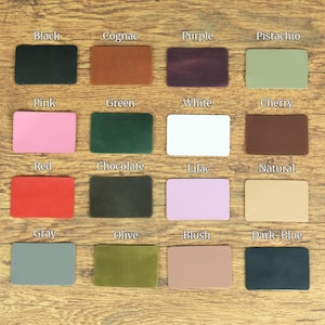 May include: A grid of sixteen rectangular leather swatches in various colors, each labeled with text including Black, Cognac, Purple, Pistachio, Pink, Green, White, Cherry, Red, Chocolate, Lilac, Natural, Gray, Olive, Blush, and Dark-Blue.
