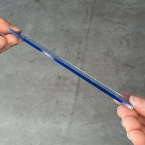 May include: A clear plastic ruler with a blue stripe down the center.