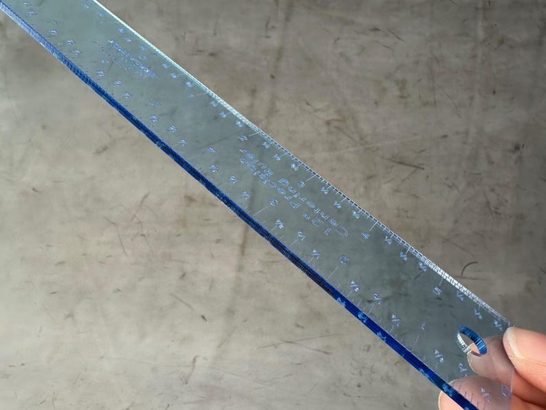 May include: A clear blue plastic ruler with inch markings. The ruler has a hole in the upper right corner.
