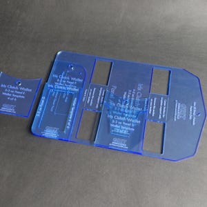 May include: A clear blue plastic template for making a clutch wallet. The template is labeled "Iris Clutch Wallet" and includes instructions for making different sizes of wallets. The template is 4 of 6.