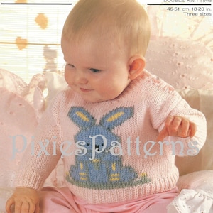 May include: A pink knitted baby sweater with a blue bunny design. The sweater is made with double knitting and comes in three sizes. The text "Pixies Patterns" is visible on the sweater.